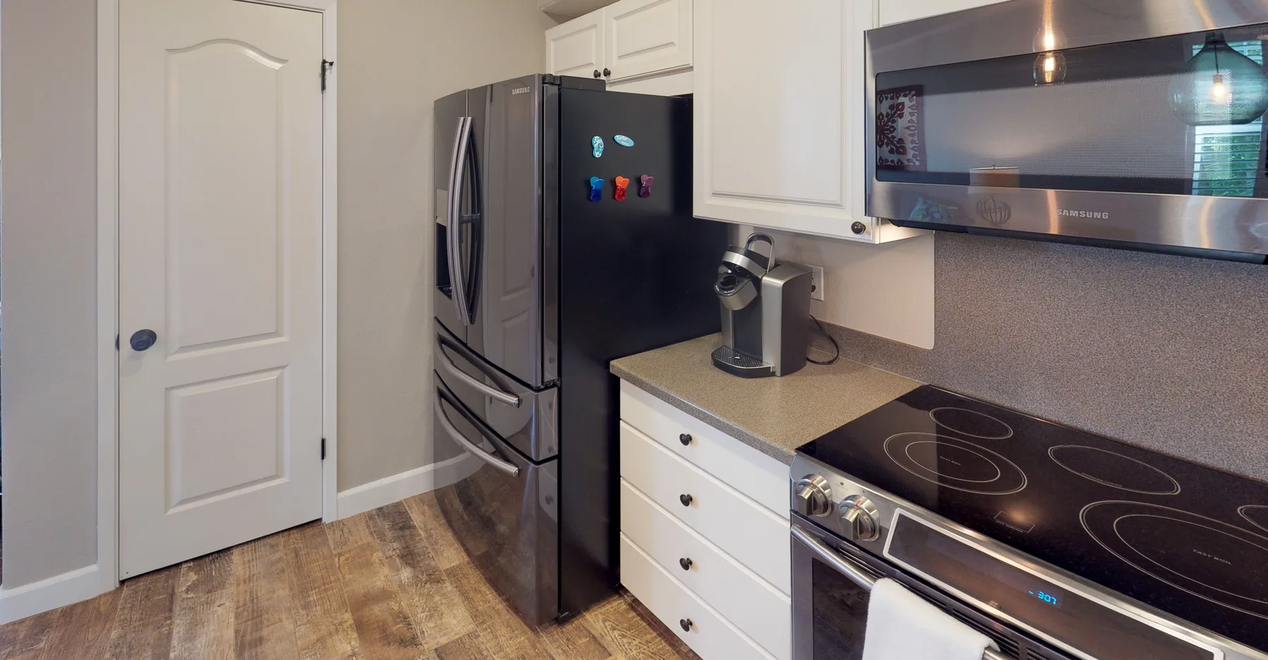 Una cocina con refrigerador, encimera y placa de cocción.