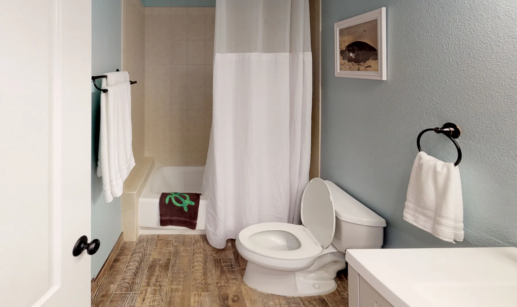 Un baño con un inodoro junto a una cortina de ducha y una bañera.