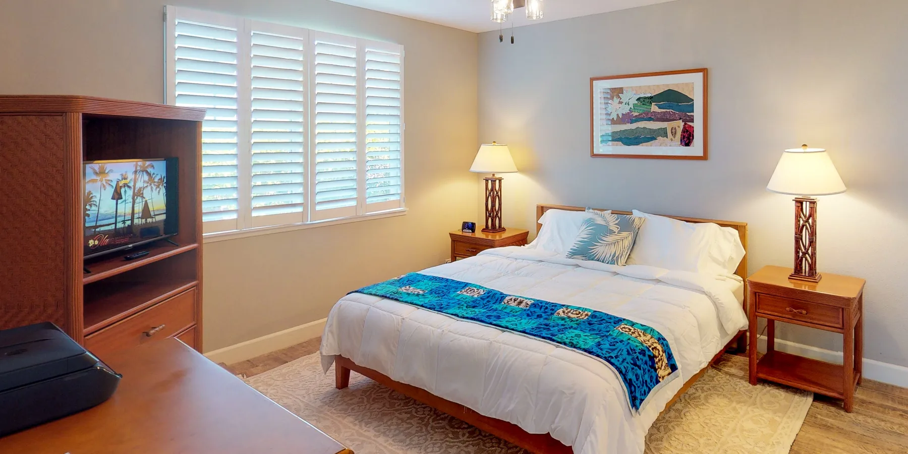 Un dormitorio con una cama bien tendida y ventanas luminosas con persianas.