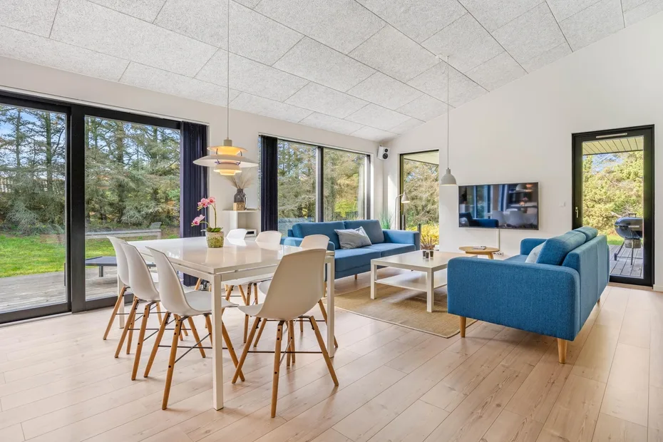 Una sala de estar y comedor diáfana con asientos azules y una mesa de comedor.