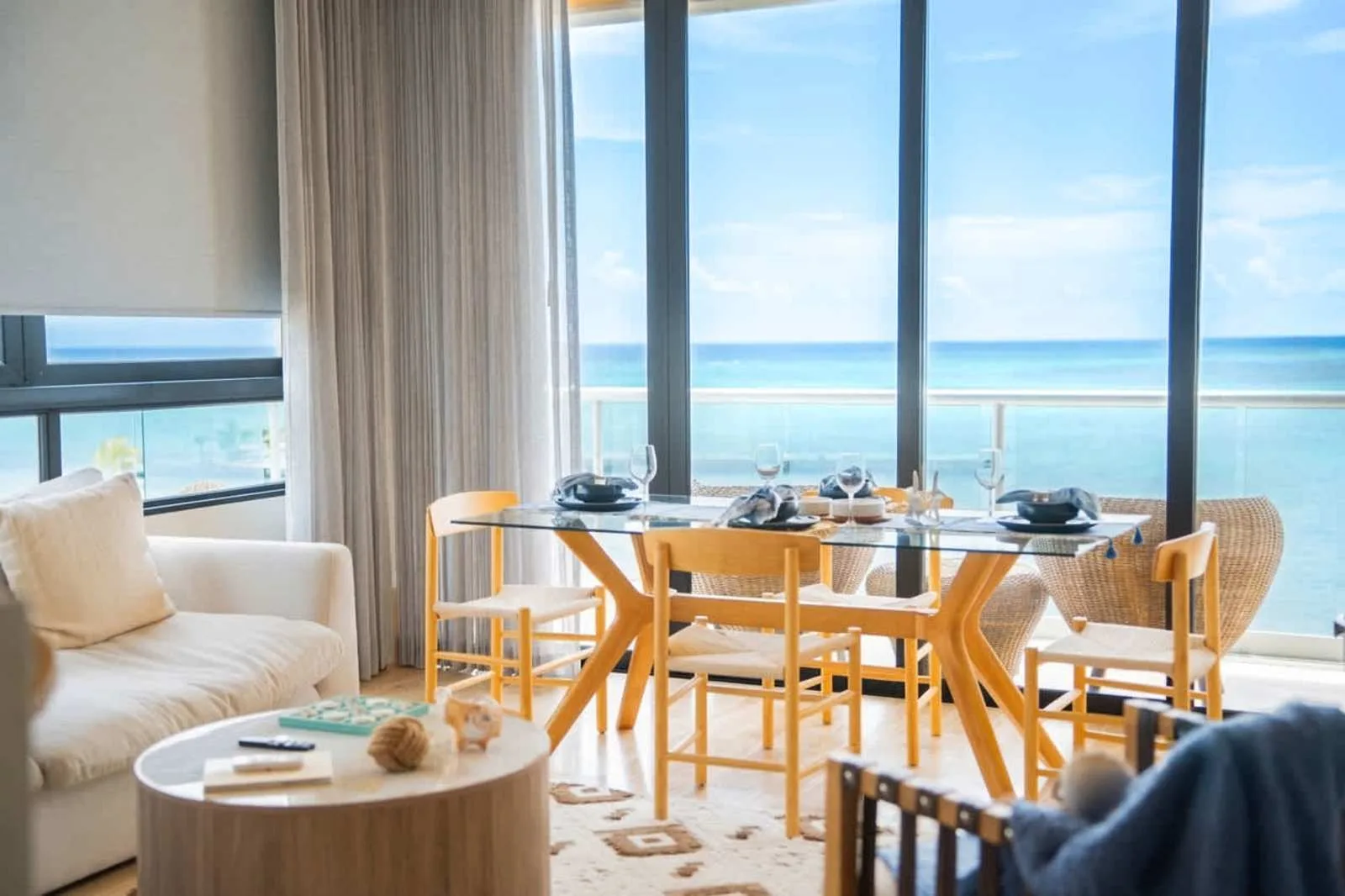 Una zona de comedor junto a grandes ventanales da al océano.