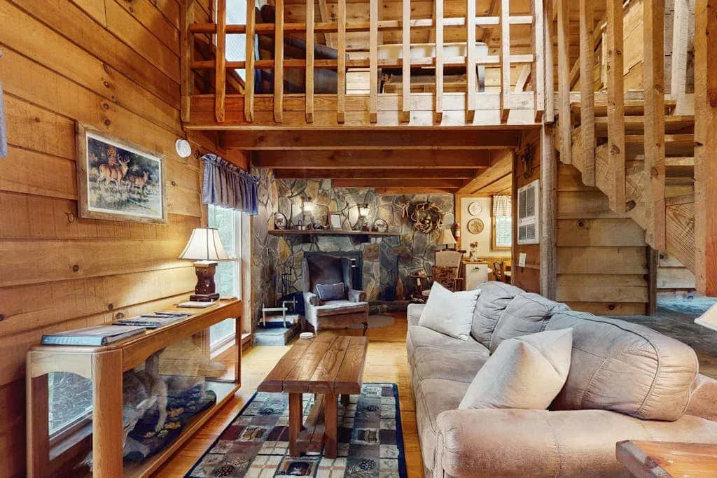Una sala de estar revestida de madera con chimenea y asientos.