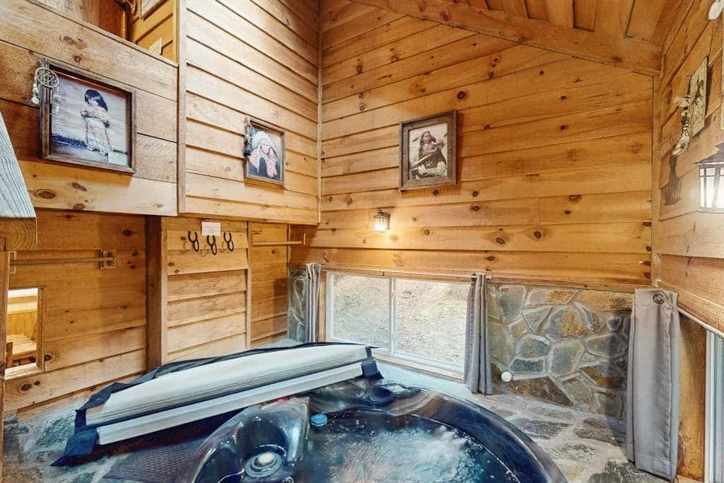 Un espacio de jacuzzi de madera con una gran tina burbujeante bajo paredes de madera.