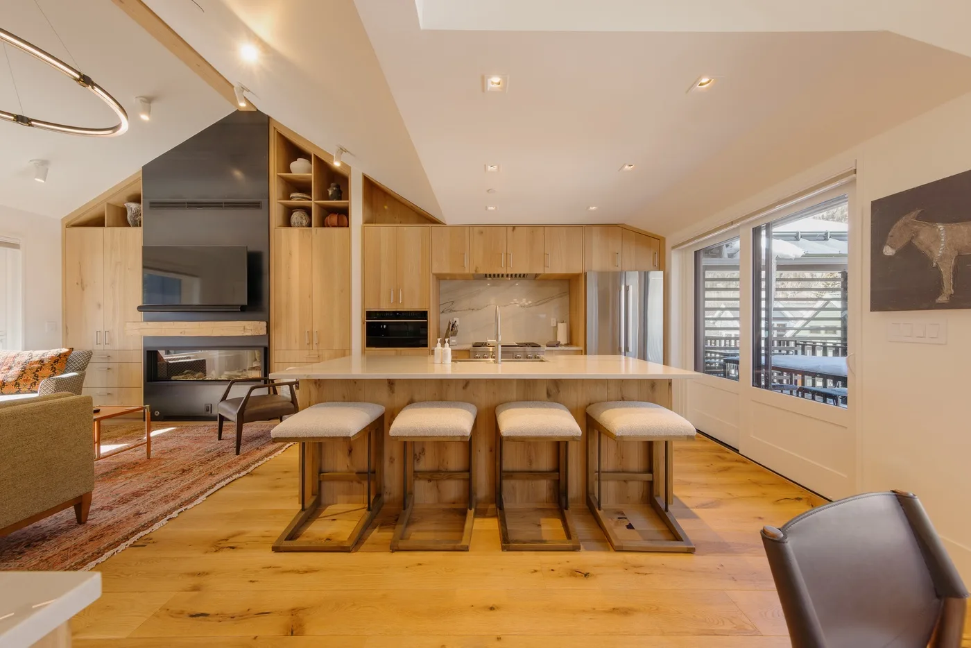 An open-plan kitchen and dining area with a long counter and stools.