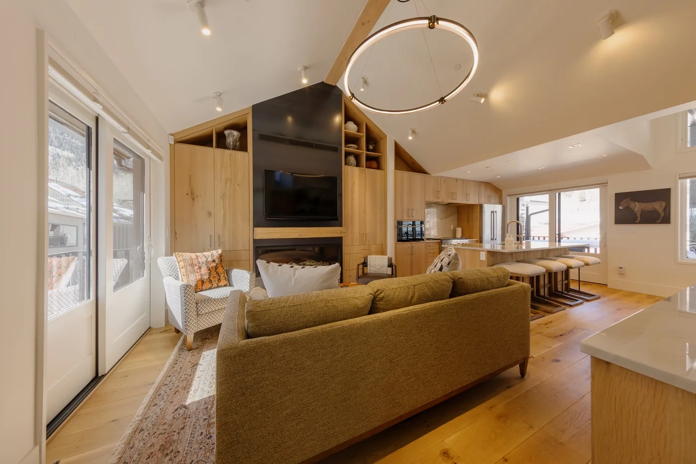 An open-plan living and kitchen area with seating around a central television.