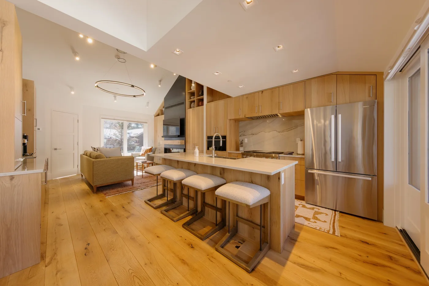 An open-plan kitchen and living area with a central island and seating.