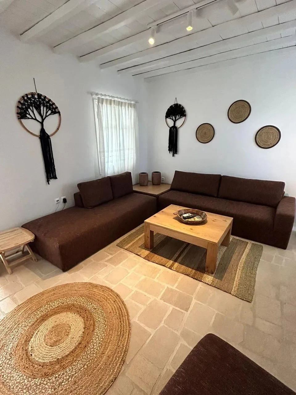 Una sala de estar con asientos marrones y una mesa de centro de madera.