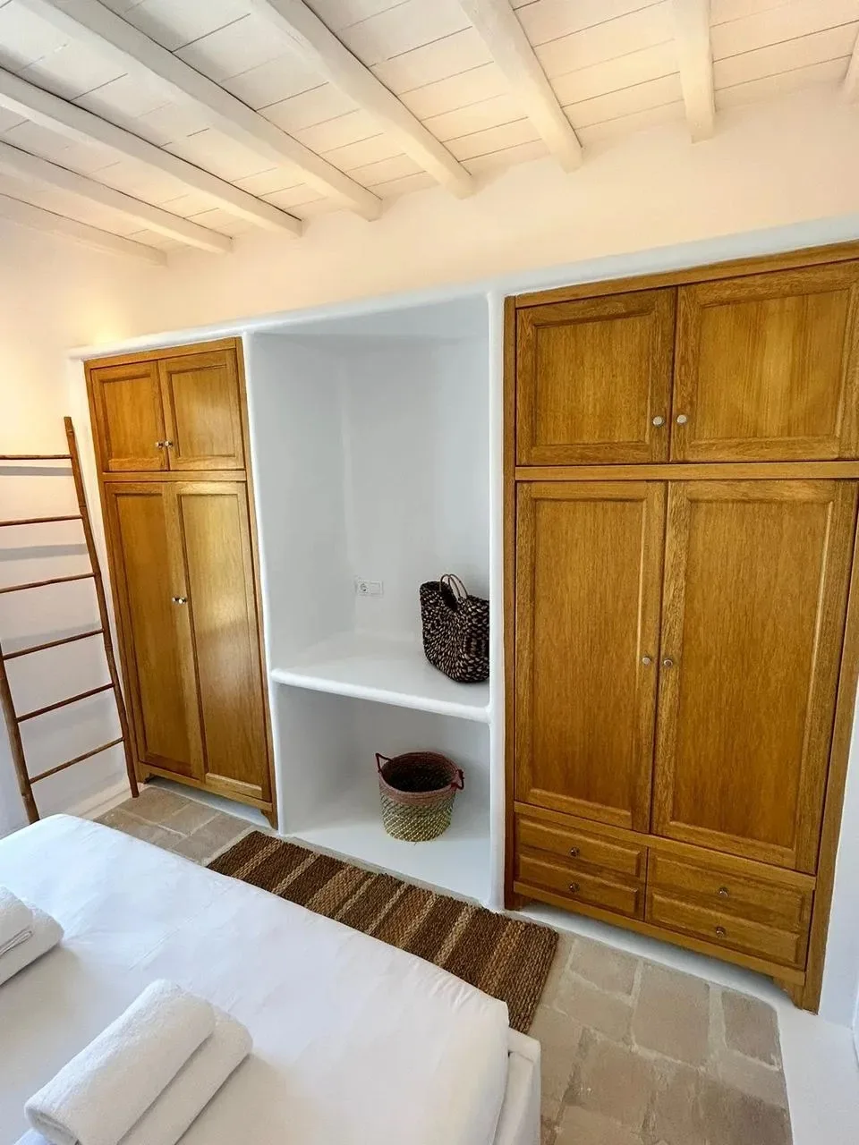 Un dormitorio con ropa de cama blanca y armarios de madera.