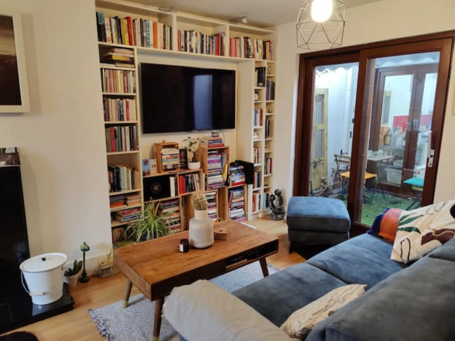 A living room with a television set into a wall of bookshelves.