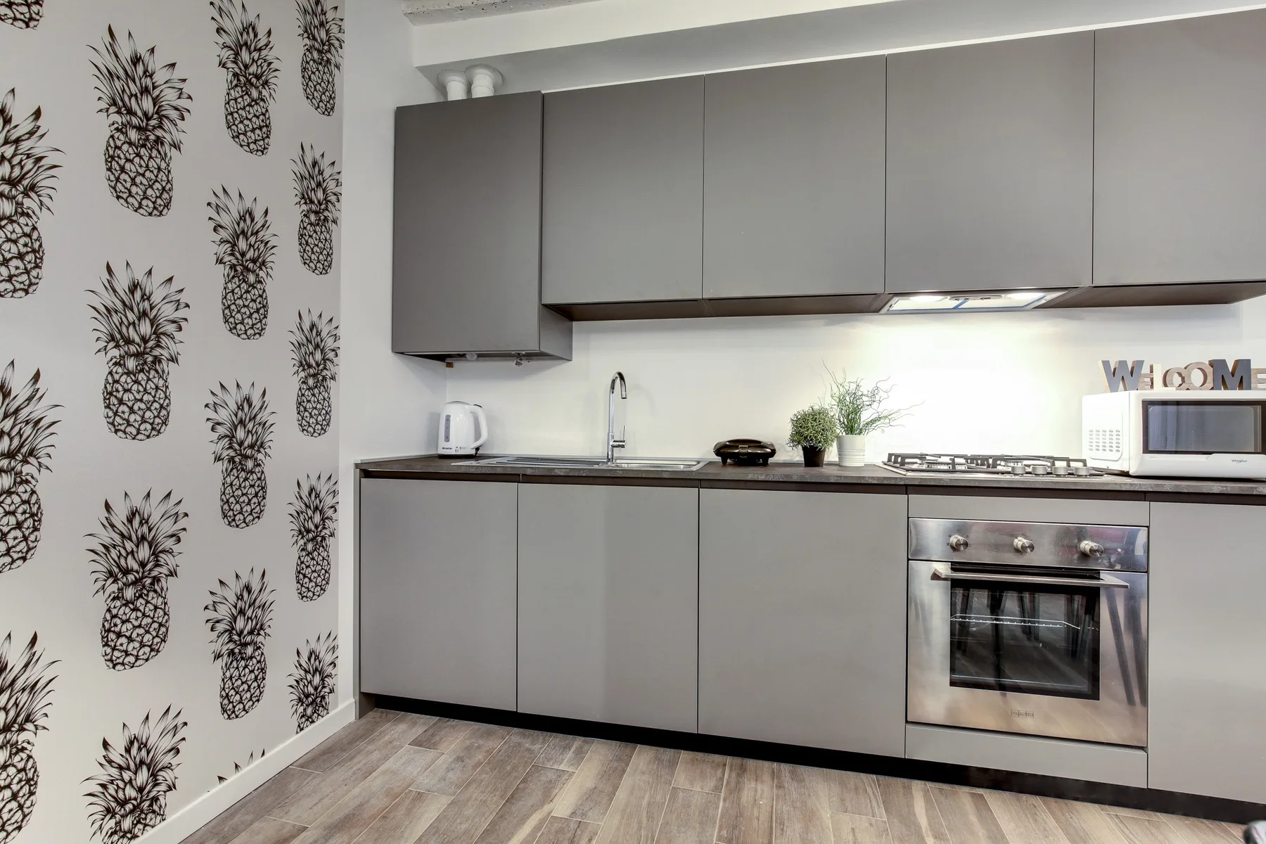 Una cocina moderna con gabinetes grises, una encimera y un horno.