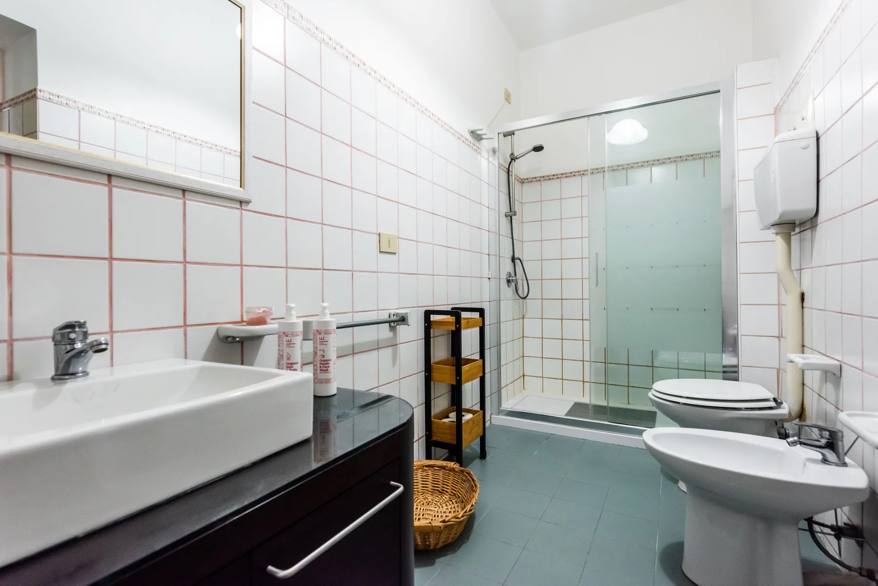 A tiled bathroom with a sink, toilet, and glass shower.