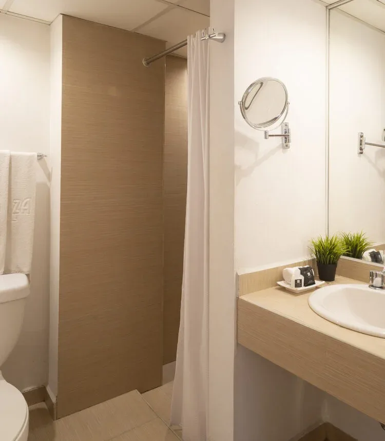 Private bathroom with shower and sink in a Stanza Hotel single room