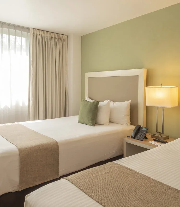 Double bed beside a window in a Stanza Hotel double room