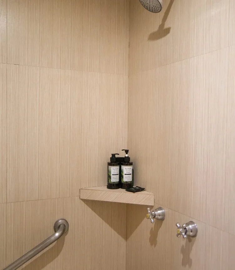 Shower with toiletries in a Stanza Hotel single-room bathroom