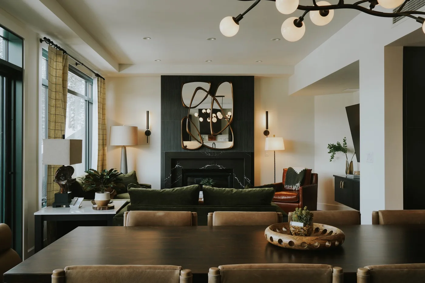A living room with seating arranged around a fireplace and coffee table.