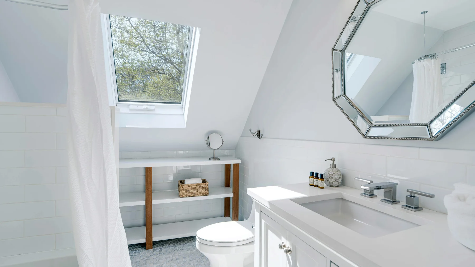 A bright bathroom with a vanity, toilet, and large mirror.