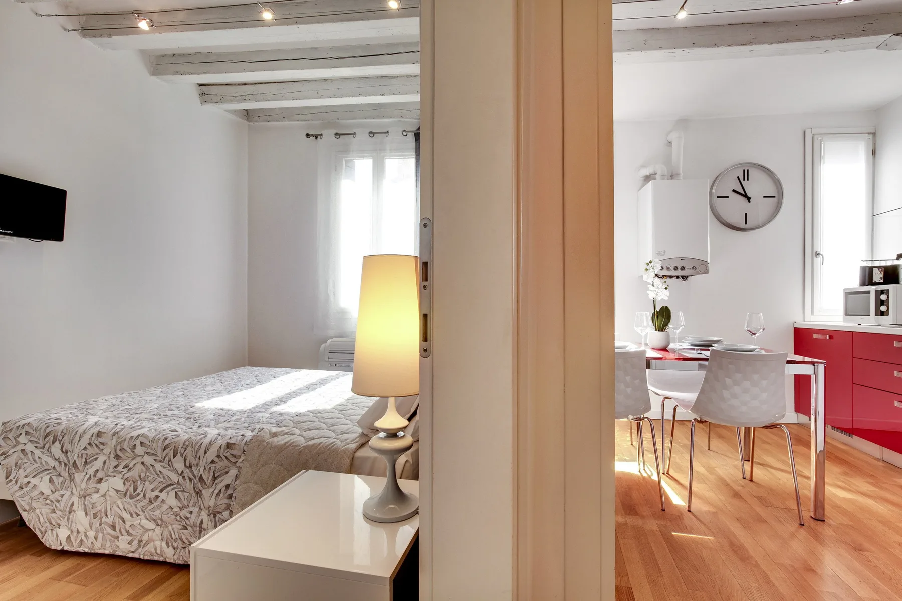 A bedroom and dining area are visible on either side of a central doorway.
