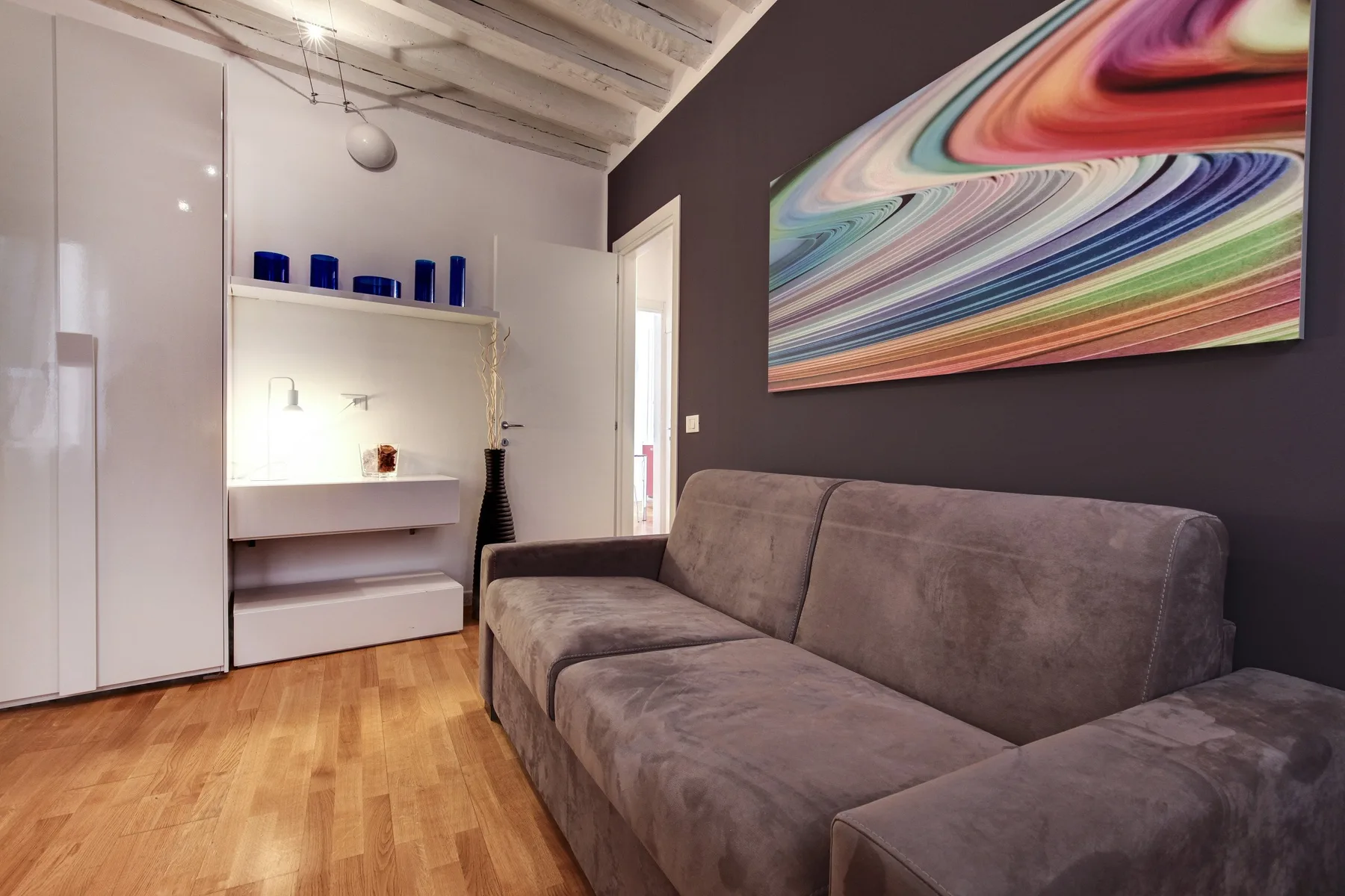 A living room with a gray sofa and colorful abstract wall art.