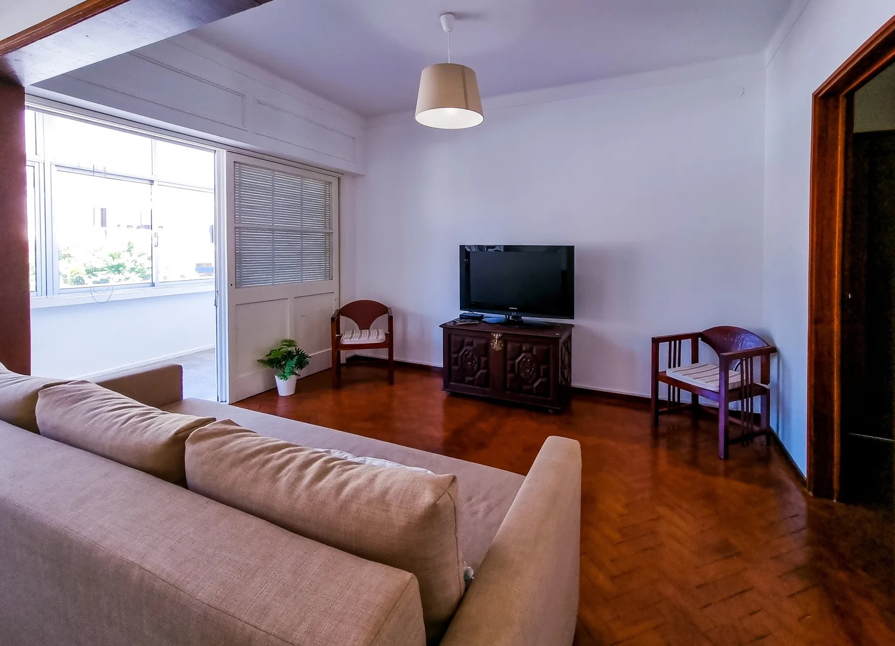 Una sala de estar con asientos, un televisor y una ventana con vistas al exterior.