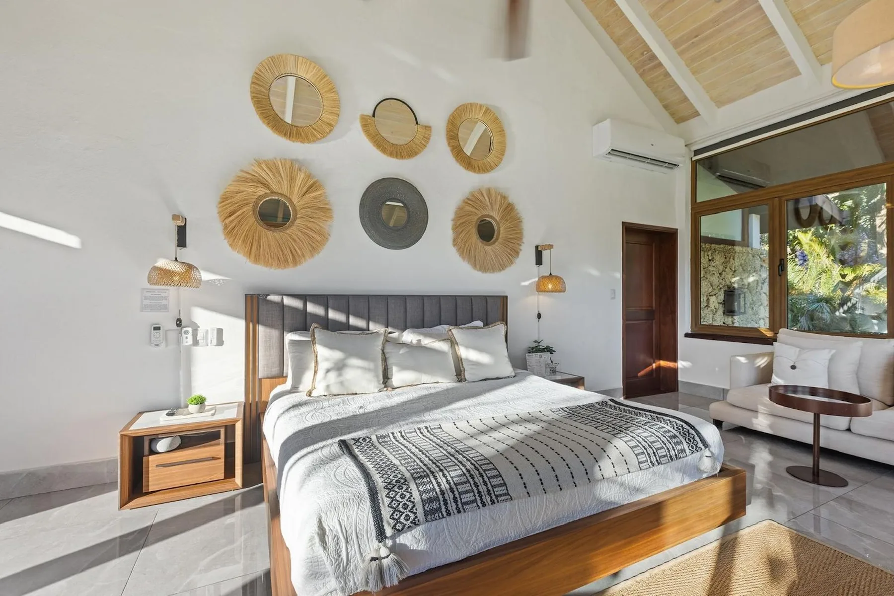 Un dormitorio con una cama bien tendida y adornos circulares en la pared.