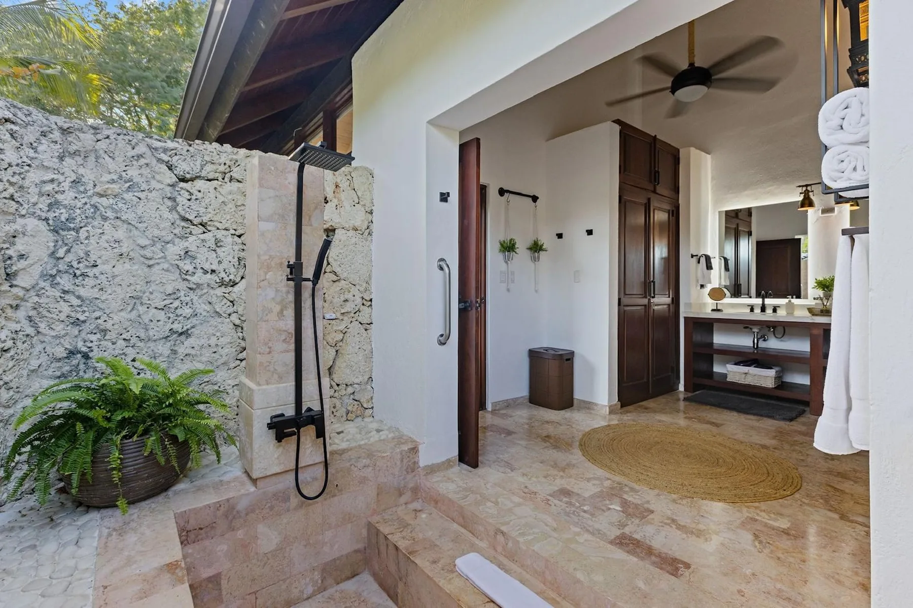 Un baño con una zona de ducha abierta y un lavabo junto a una puerta.
