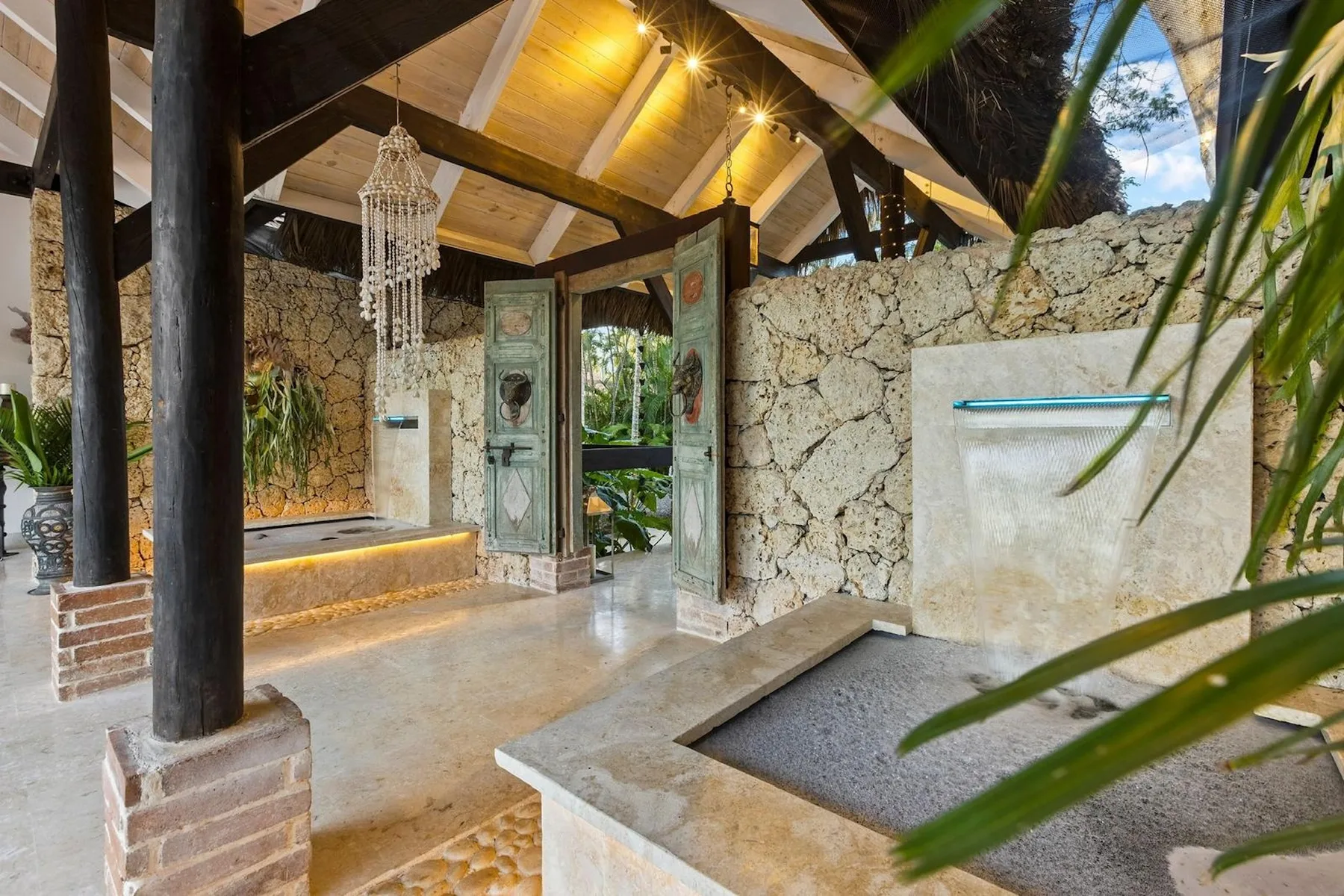 Un baño con paredes de piedra, ducha de vidrio y bañera empotrada.