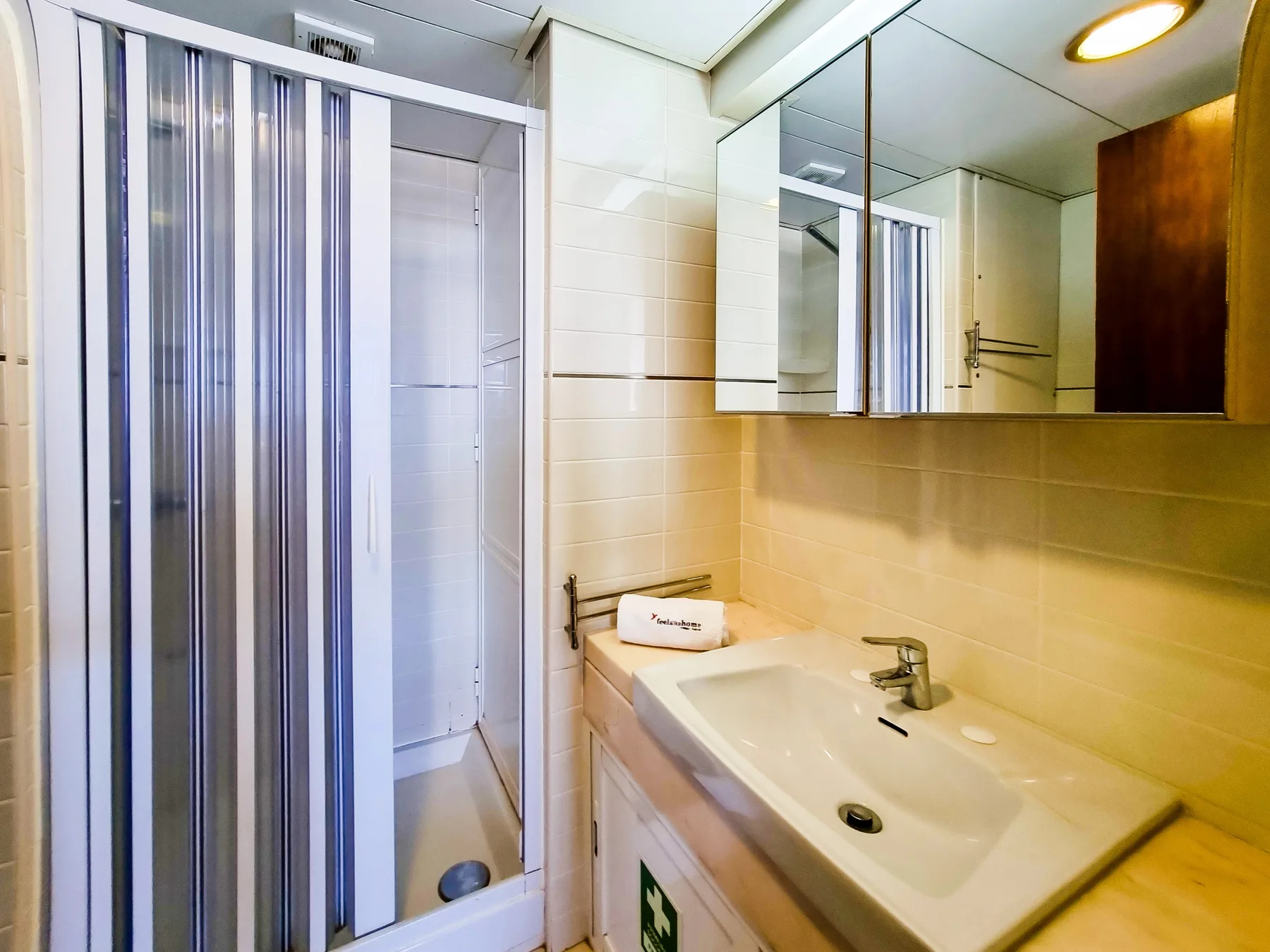 A bright bathroom with a sink and a shower.
