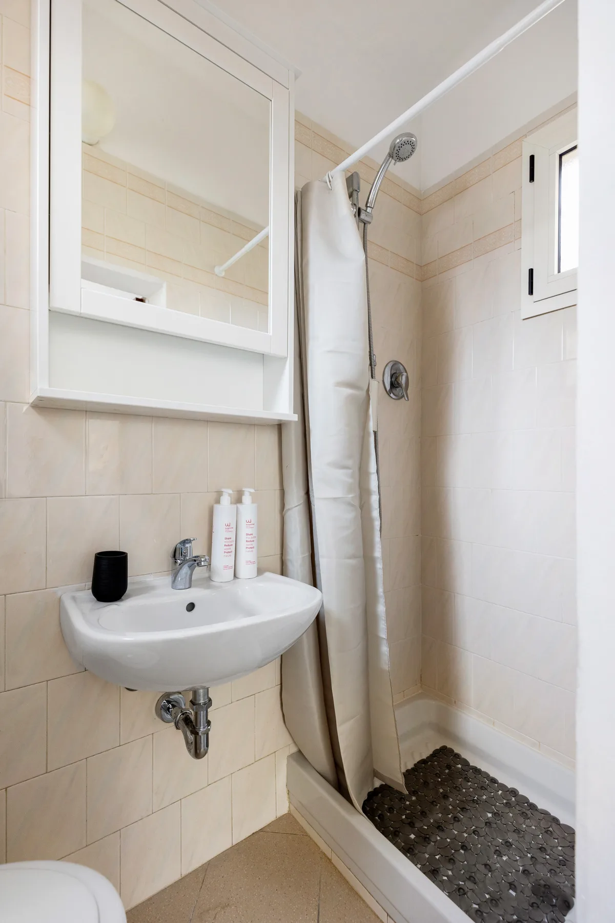 Un baño alicatado con lavabo y ducha.