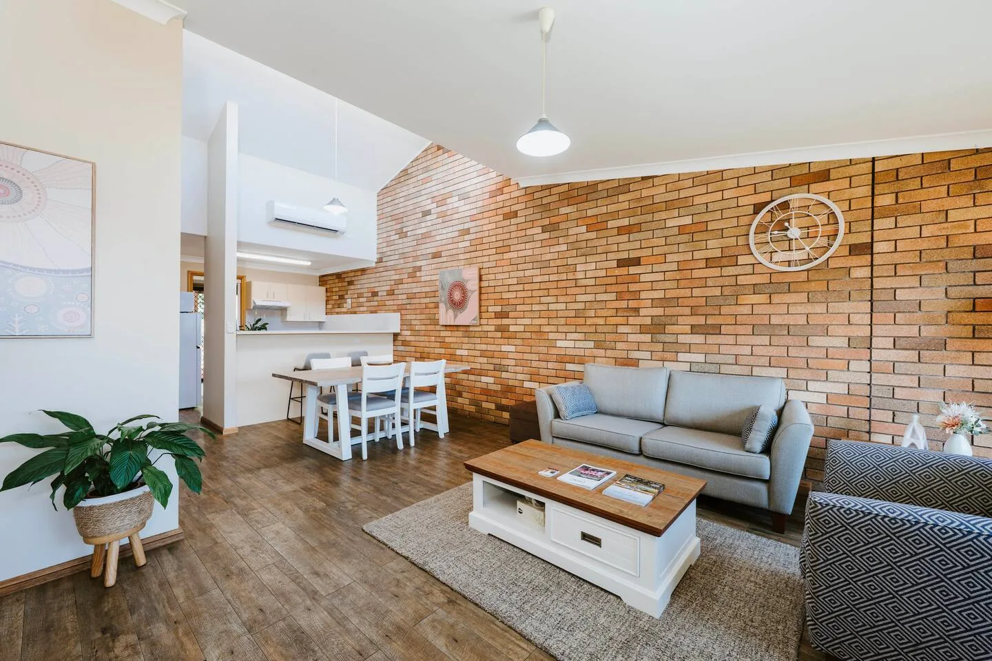 A living room with a sofa and coffee table beside a dining area.