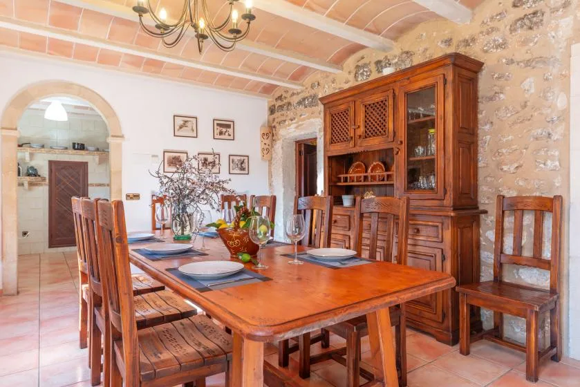 Un comedor con una mesa y sillas de madera bajo un techo abovedado.