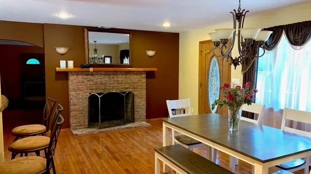 Un comedor con una mesa junto a una chimenea de ladrillo.