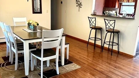 Un comedor con mesa y sillas junto a una barra de cocina.