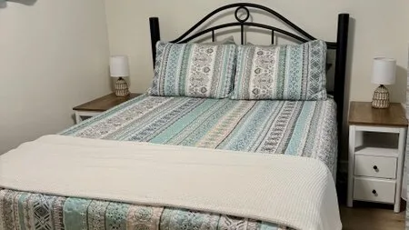 Un dormitorio con una colcha estampada y almohadas a juego.