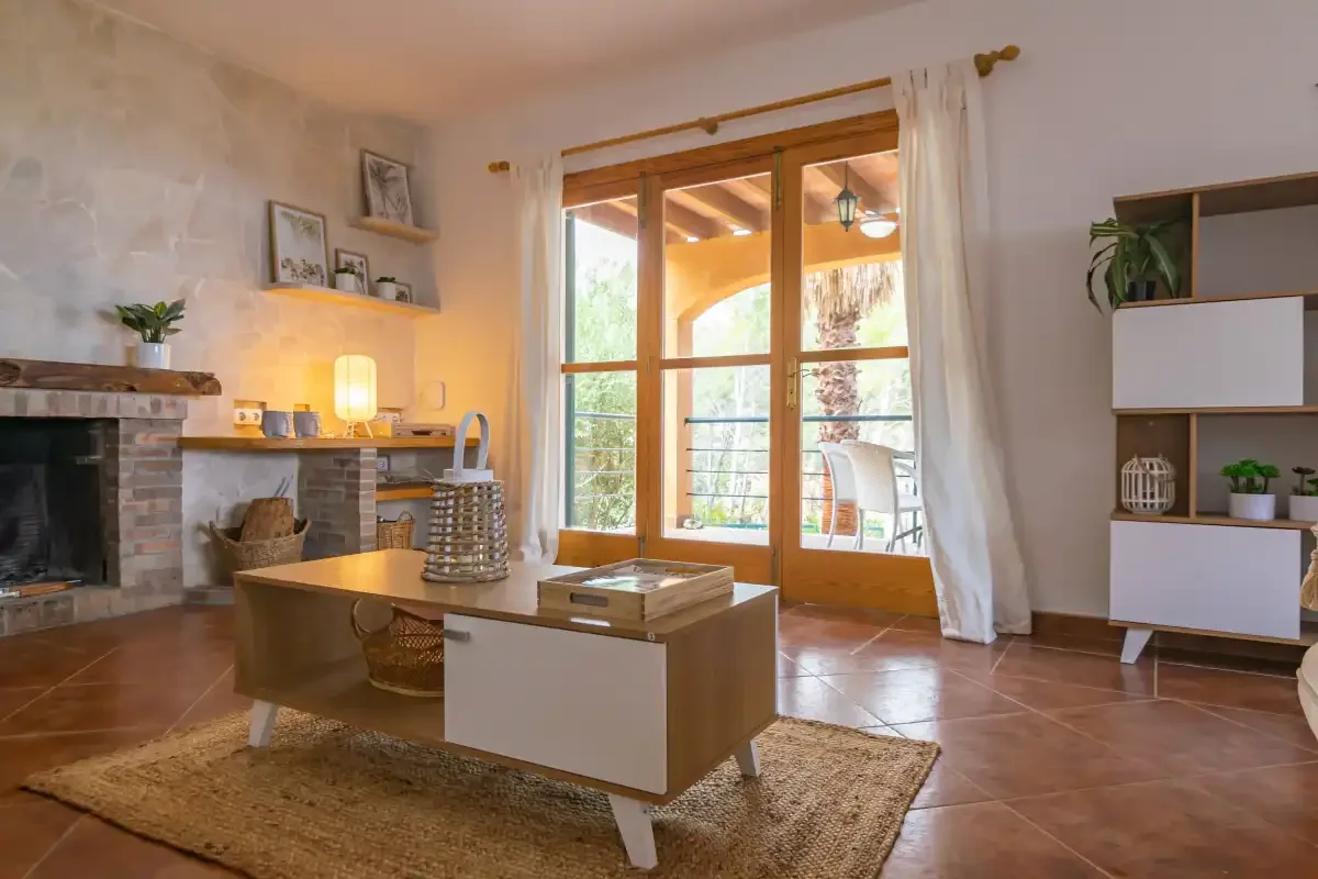 A living room with a fireplace and large glass doors opening onto a balcony.