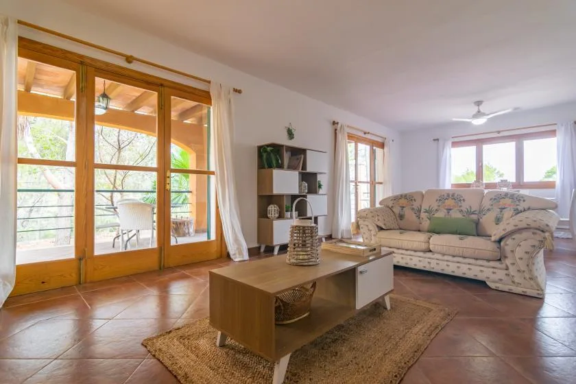 A living room with a patterned sofa and a wooden coffee table.