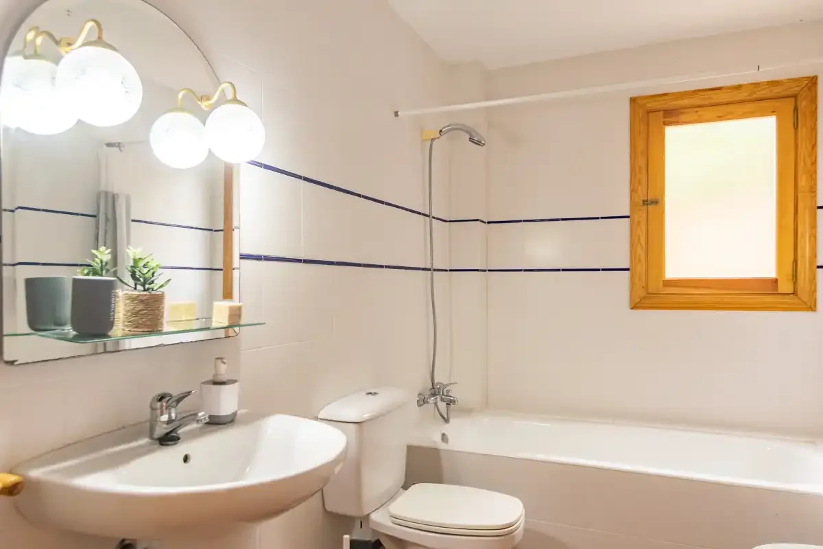 A tiled bathroom with a sink, toilet, and bathtub.