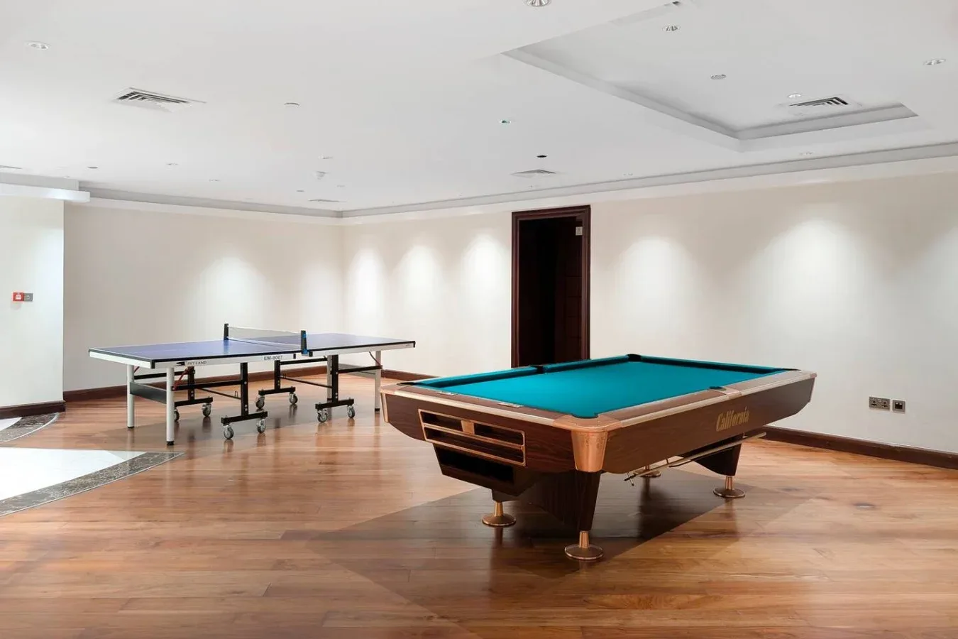 A recreation room with a pool table and a table tennis table.