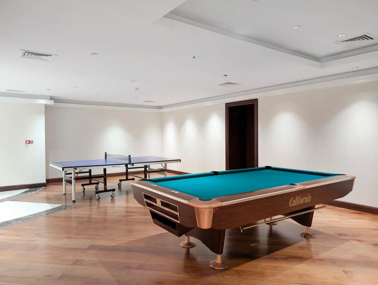 A game room with a pool table and a table tennis table.