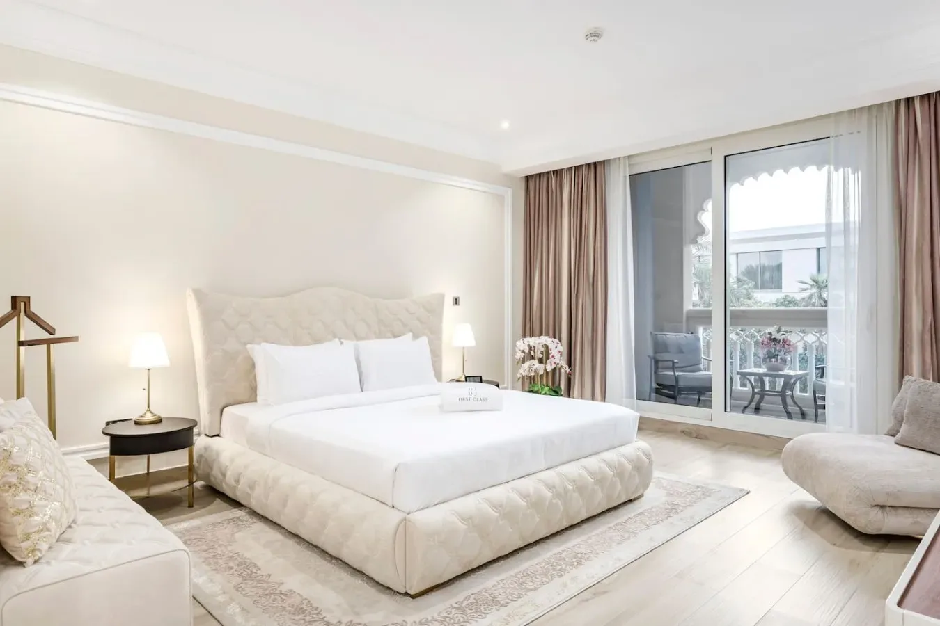 Un dormitorio luminoso con una cama grande y puertas de vidrio que dan a un balcón.