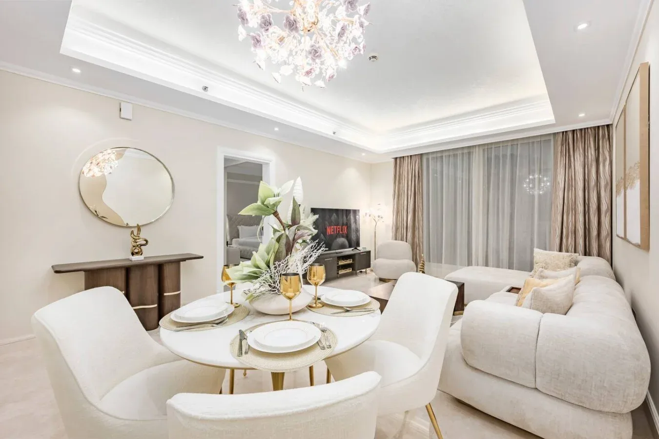 A bright living and dining area with a round table set beside the seating.