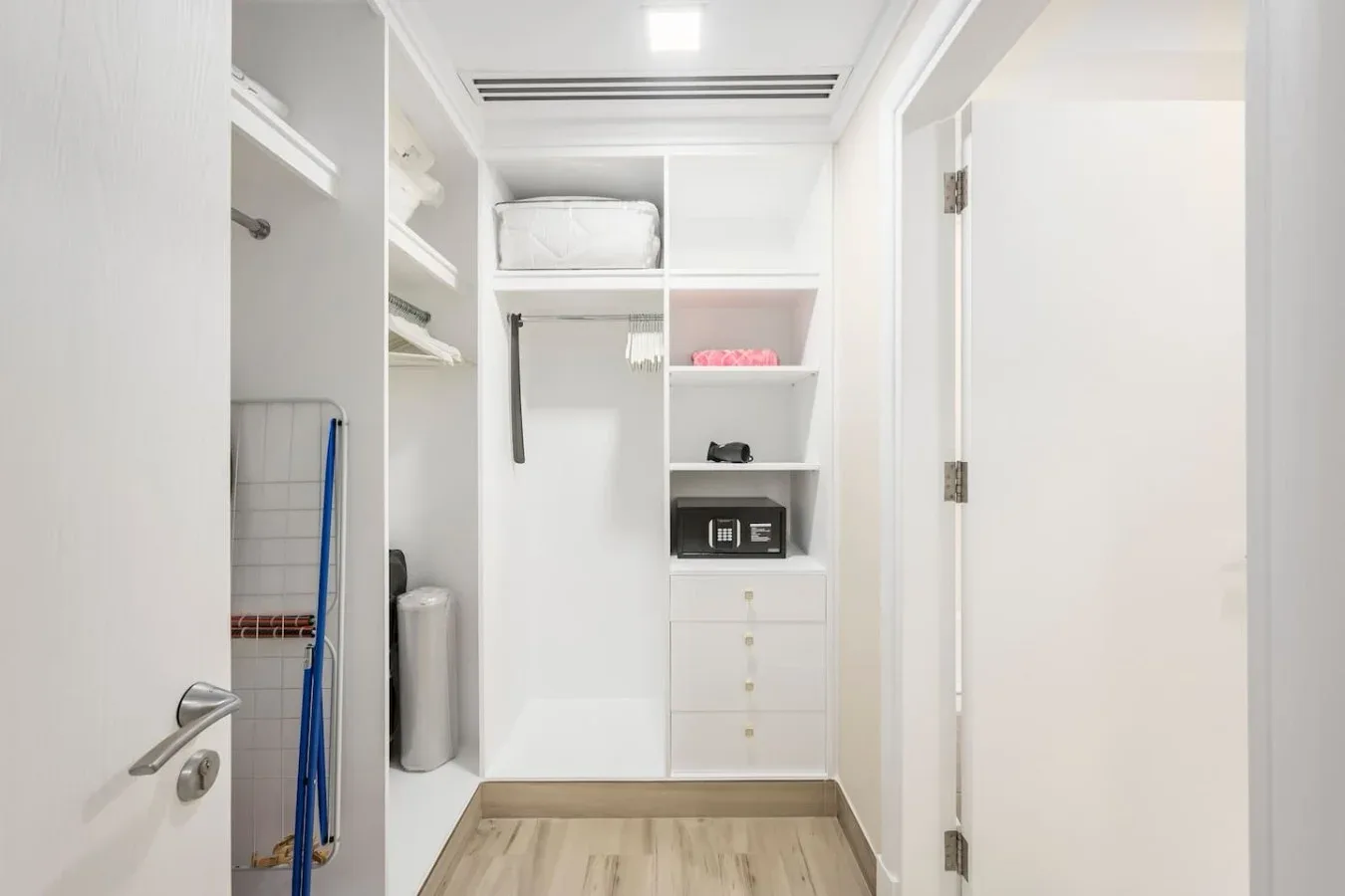 A bright walk-in closet with open shelves, drawers, and hanging space.