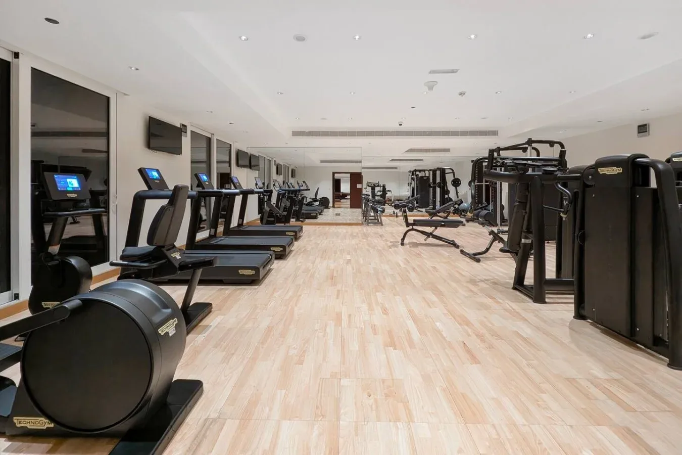 A gym with rows of exercise machines and treadmills.