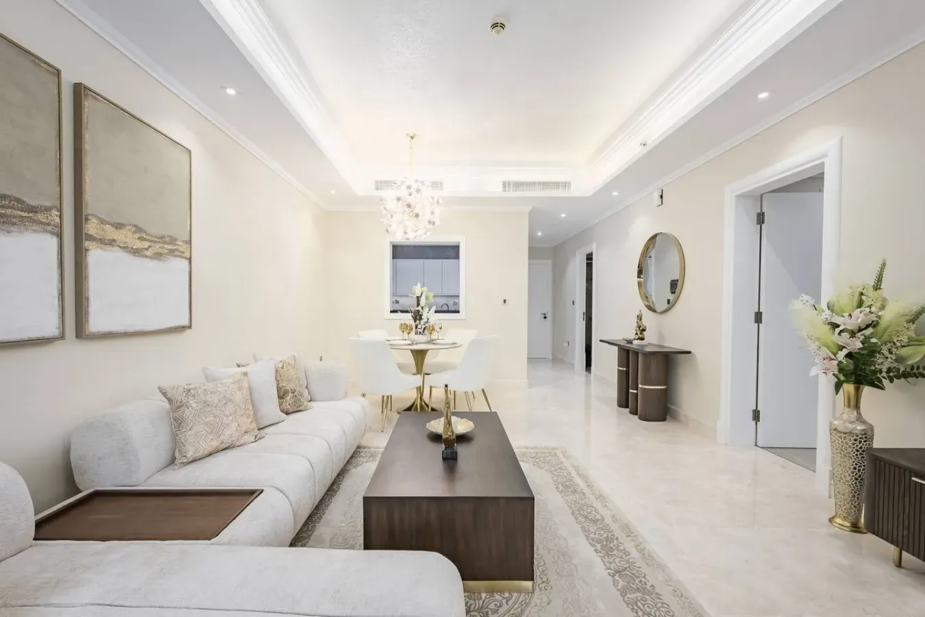 A bright living room with seating, a coffee table, and framed artwork.