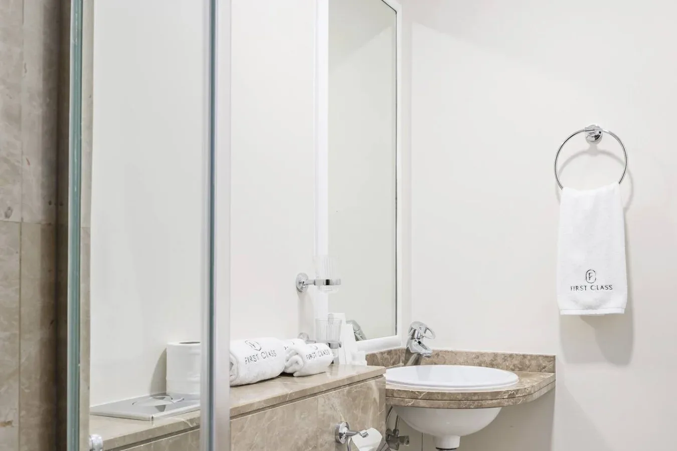Bathroom vanity with a sink, mirror, and towel hanging on the wall.