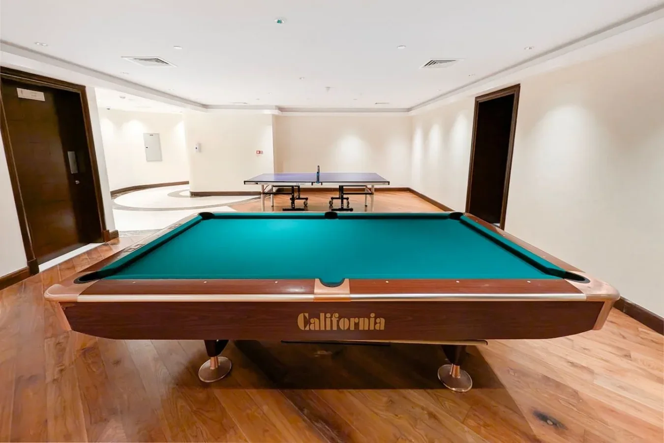 A recreation room with a green billiards table and a ping-pong table.