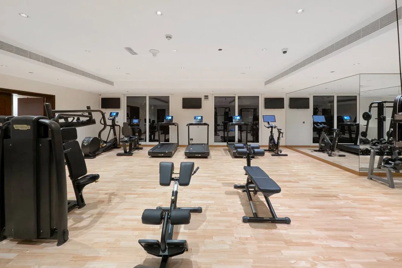 A fitness room with exercise machines and workout benches.