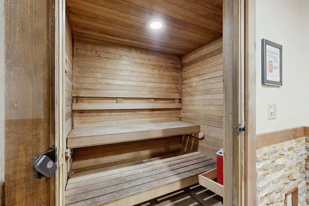 Una sauna de madera con bancos escalonados y una luz en el techo.