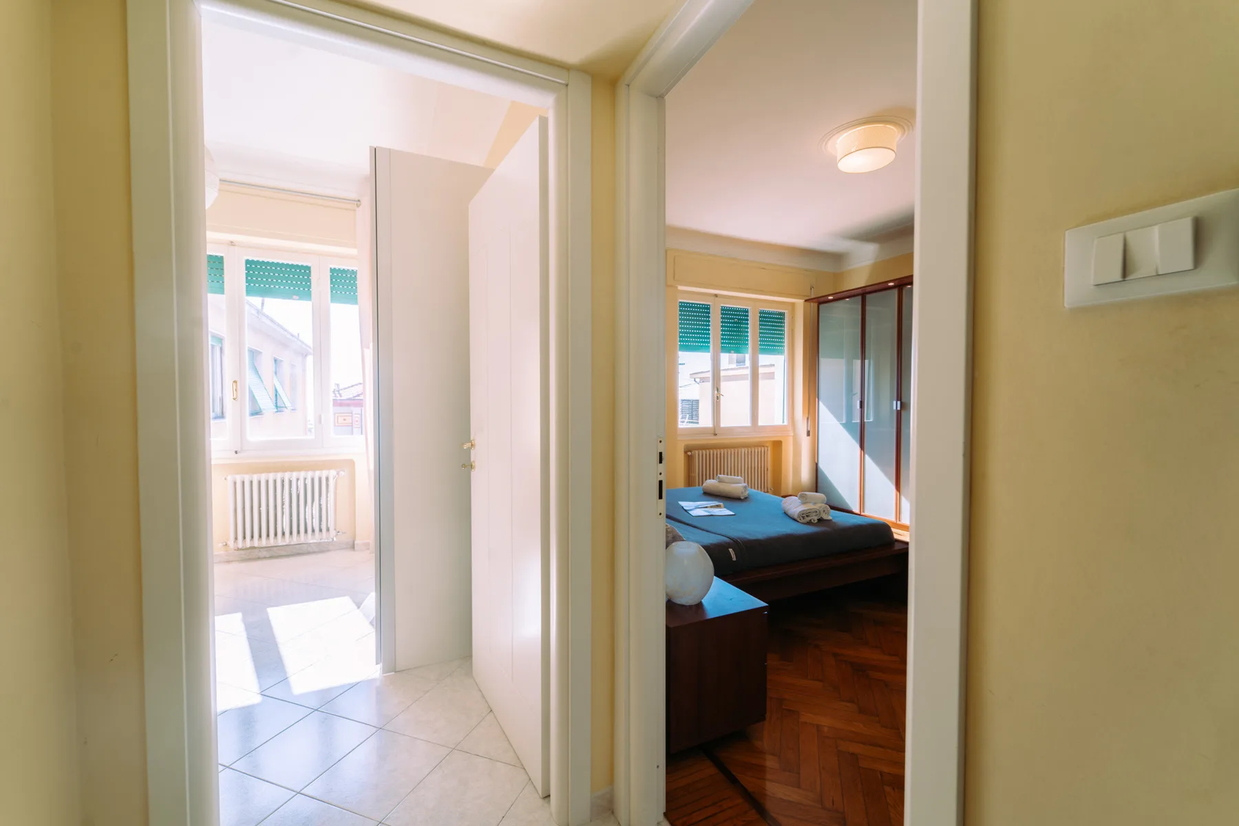 A bedroom with a bed is visible through an open doorway.