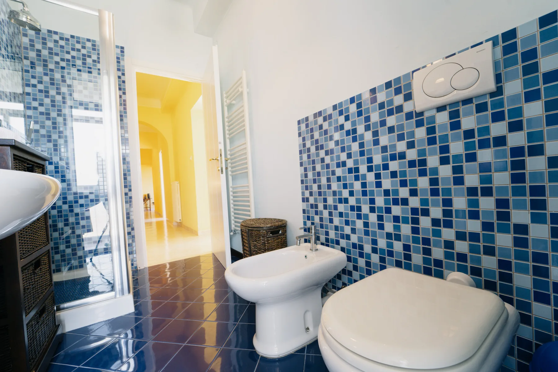 A tiled bathroom with a shower, sink, and toilet.