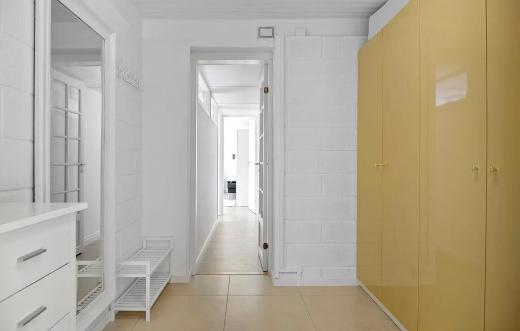 A bright hallway with built-in storage and a clear view through an open doorway.